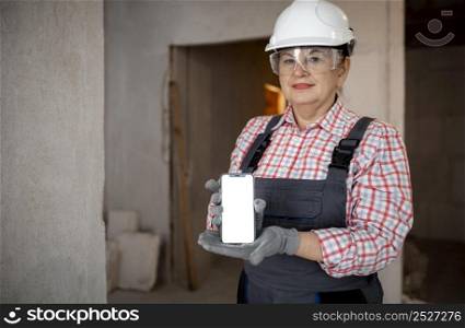 female construction worker with helmet holding smartphone
