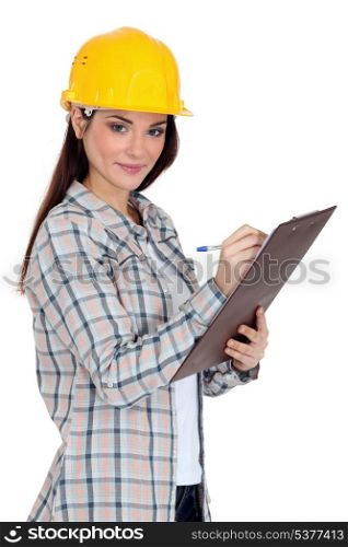 Female construction worker writing on her clipboard.
