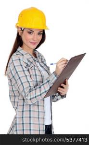 Female construction worker writing on her clipboard.
