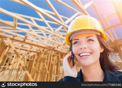 Female Contractor In Hard Hat Using Cell Phone At Construction Site.