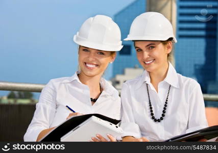 female contractors in a front of building site (focus on blonde)