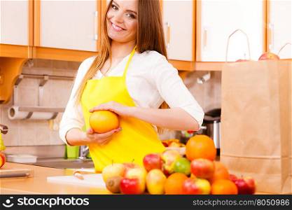 Female cook working in kitchen.. Hobby diet salad concept. Female cook working in kitchen. Young lady in apron preparing healthy food out of natural fruits.