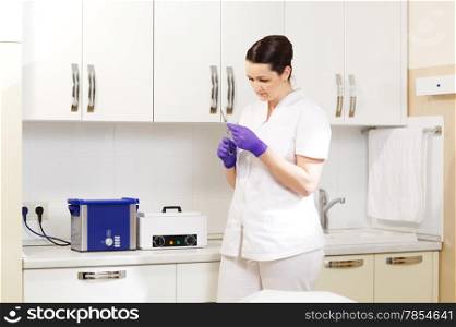 Female cosmetician in the salon preapring tools to be sterilized