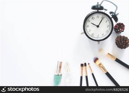 Female cosmetics and accessories with alarmclock on white background with copy space, Flat lay