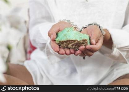 Female crystal healing therapist hand holding green Chrysoprase crystal. Chakra healing treatment with crystals.. Crystal Healing Therapy with Green Chrysoprase Crystal