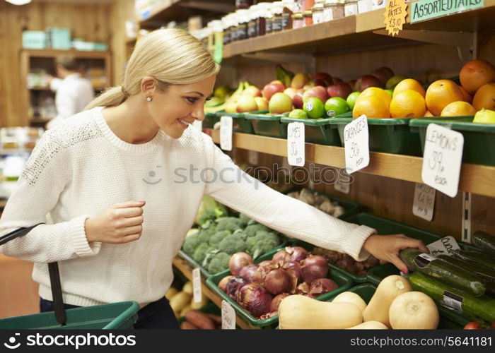 Female Customer At Vegetable Counter Of Farm Shop