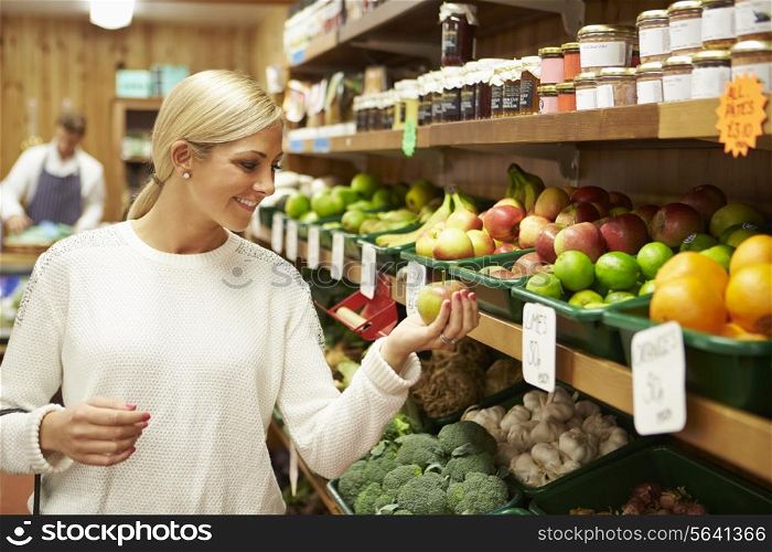 Female Customer At Vegetable Counter Of Farm Shop