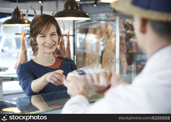 Female Customer Buying Meat In Butchers Shop