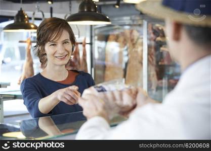Female Customer Buying Meat In Butchers Shop