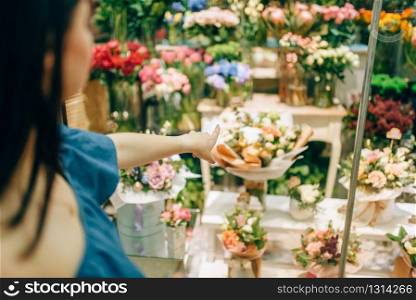 Female customer chooses flowers for bouquet preparation. Floral business, florist shop