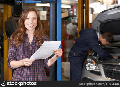 Female Customer In Auto Repair Shop Satisfied With Bill For Car Repair