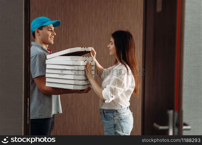 Female customer on the doorstep and pizza delivery boy, delivering service. Deliver from pizzeria and woman indoor. Female customer on doorstep and pizza delivery boy