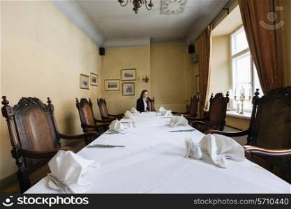 Female customer sitting at dining table in restaurant