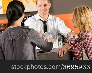 Female customers paying by cash euro in bar to bartender