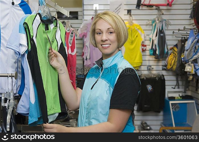 Female cyclist in bike shop choosing cycling top