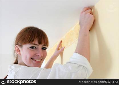 Female decorator hanging wallpaper border