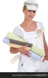 Female decorator holding rolls of wallpaper