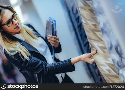 Female decorator looking at fabric samples in home design salon