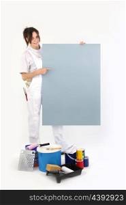 Female decorator pointing to a blank poster