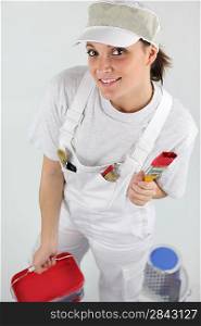 Female decorator with pots of red and blue paint