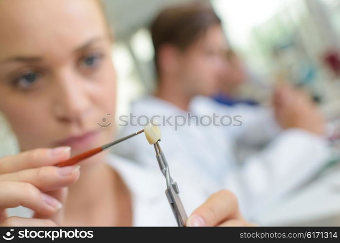 Female dental technician working on individual tooth