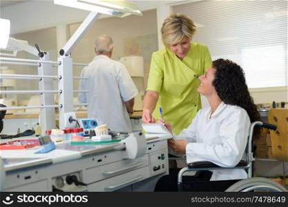 female dentist and apprentice in wheelchair