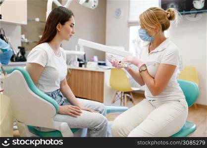 Female dentist and patient at appointment in clinic, stomatology. Orthodontist in uniform and customer, medical worker, medicine and health, professional teeth care, dentistry. Female dentist and patient, appointment in clinic