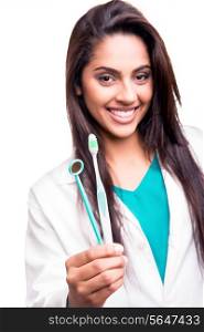 Female dentist doctor showing dental mirror and toothbrush - Focus on hand