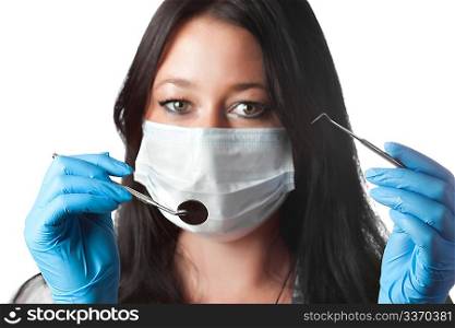female dentist in mask holding tool and mirror isolated on white. focus on tools