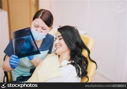 female dentist showing teeth x ray patient