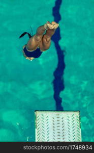 Female diver jumping into the pool from diving board