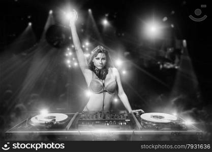 Female dj working in the disco while wearing just sexy lingerie
