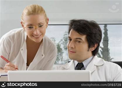 Female doctor and a male doctor looking at a laptop