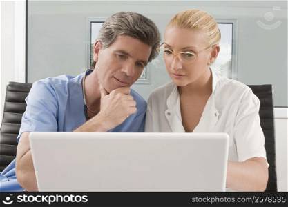 Female doctor and a male surgeon sitting in a clinic