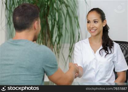 female doctor and patient handshaking at office