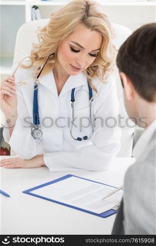 Female doctor and patient reading contract at pad. Physical agreement form signature, disease prevention, ward round reception, consent contract sign, prescribe remedy, healthy lifestyle concept. Female doctor with contract