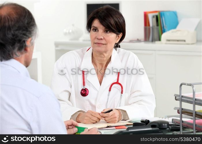 Female doctor at her desk with a patient