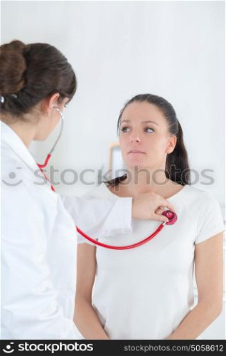 female doctor ausculting patient with stethoscope