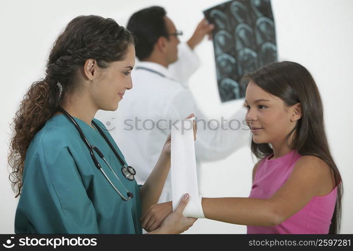 Female doctor bandaging a girl&acute;s hand