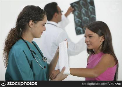 Female doctor bandaging a girl&acute;s hand