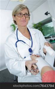 female doctor bandaging male hand sprained wrist
