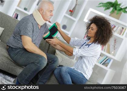 female doctor checking the blood pressure of her senior patient