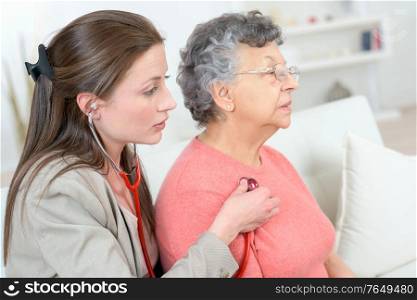 female doctor examine senior patient woman at home