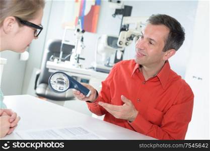 female doctor examining eyes of adult male patient