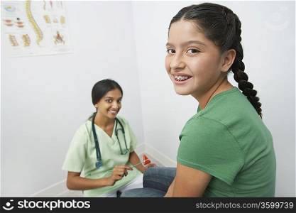 Female doctor examining girl with reflex hammer