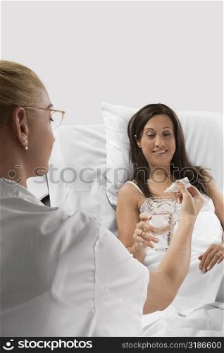Female doctor giving medicine to a mature woman