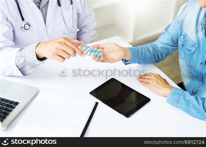 Female doctor hand holding tablet to patient in hospital room.