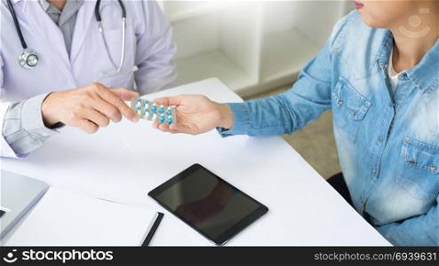 Female doctor hand holding tablet to patient in hospital room.