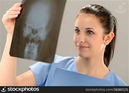 Female doctor holding and examining X-ray picture with skull