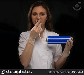 Female doctor holding can with oxygen and breathing through the mask